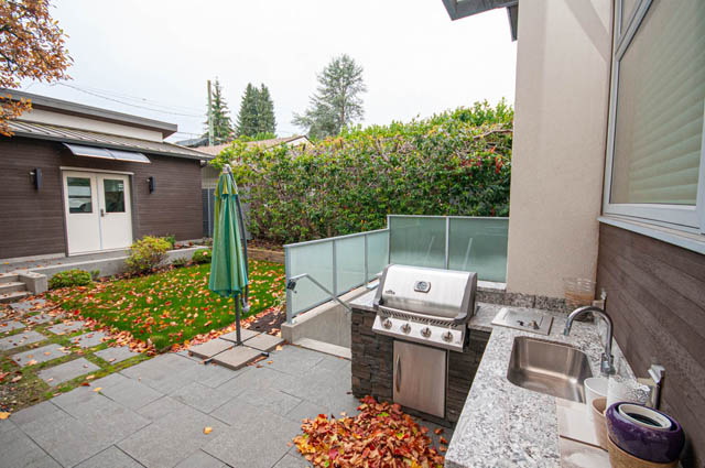 Outdoor kitchen with granite countertops and a BBQ grill, surrounded by autumn leaves. - 4504 West 12th Ave, Vancouver West Side