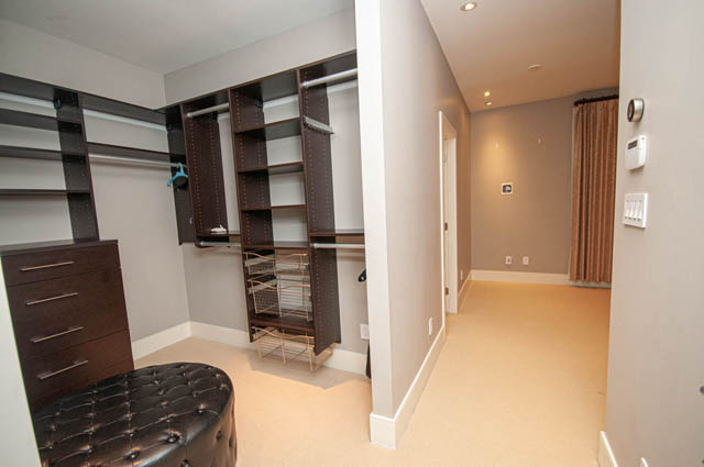 Spacious walk-in closet with built-in shelves and drawers, ideal for storage. - 4504 West 12th Ave, Vancouver West Side