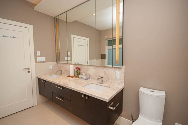 Modern bathroom with dual sinks, marble countertops, and large mirrors. - 4504 West 12th Ave, Vancouver West Side