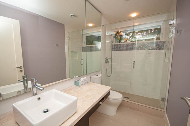 Spacious bathroom with modern vanity, glass shower, and natural light. - 4504 West 12th Ave, Vancouver West Side
