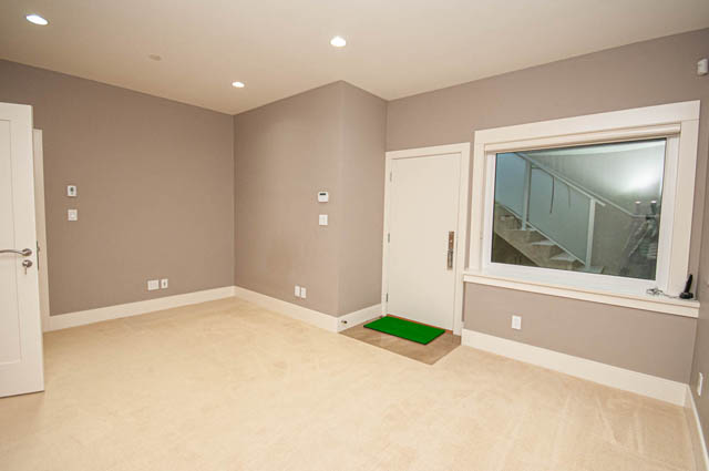 Den with built-in storage and green accents, light beige walls, and a view of the staircase. - 4504 West 12th Ave, Vancouver West Side