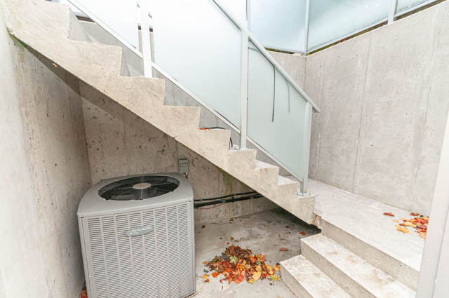 Staircase leading to a private balcony with glass railings and scattered autumn leaves. - 4504 West 12th Ave, Vancouver West Side