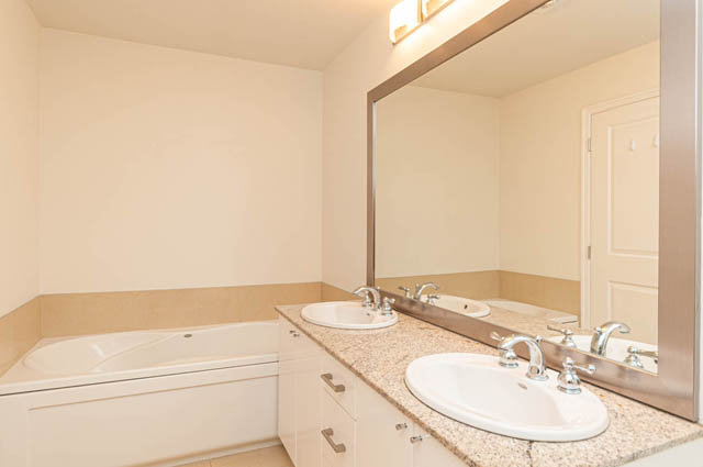 Bright bathroom with large mirror, white cabinetry, and beige countertops. - 3102 - 1211 Melville Street, Vancouver Downtown