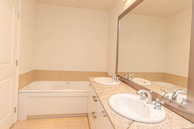 Bright bathroom with beige countertops and a large mirror. - 3102 - 1211 Melville Street, Vancouver Downtown