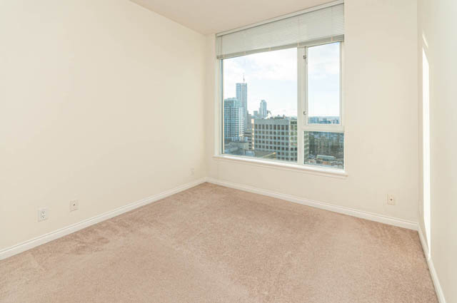Bright living room with city view and carpeted floors. - 3102 - 1211 Melville Street, Vancouver Downtown