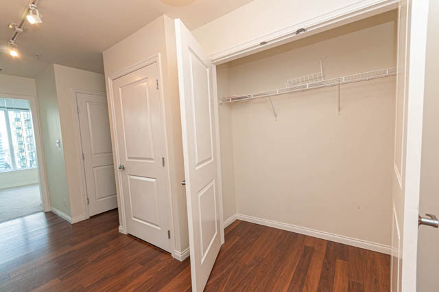Bright walk-in closet with white walls and hardwood floors. - 3102 - 1211 Melville Street, Vancouver Downtown