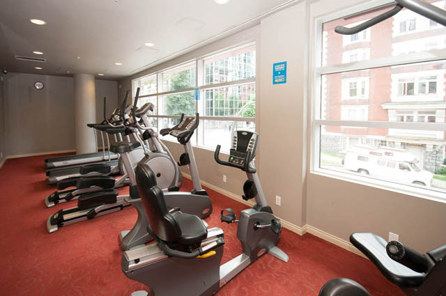 Bright gym with exercise bikes and large windows, offering a city view. - 3102 - 1211 Melville Street, Vancouver Downtown