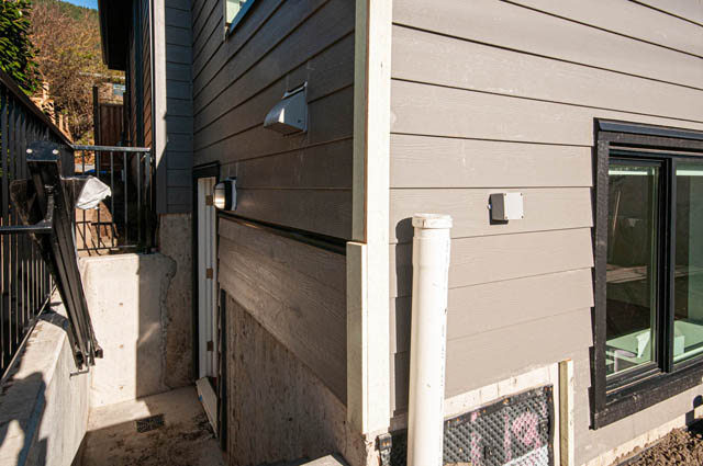 Suite with modern exterior siding, black trim, and a white pipe. - Suite - 778 Crystal Court, North Vancouver