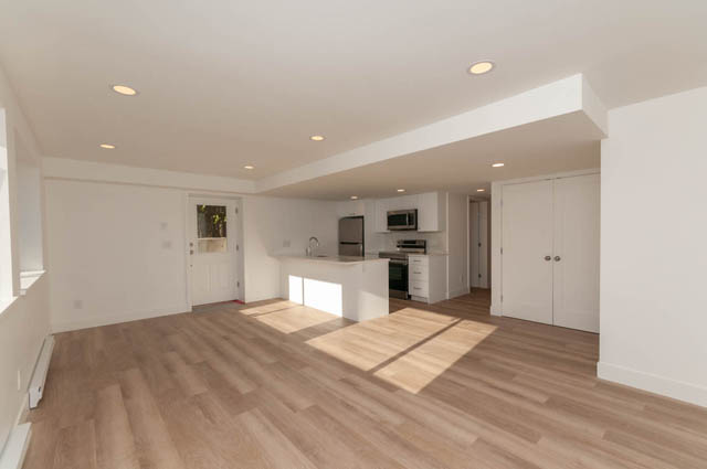 Bright kitchen with white cabinetry, stainless steel appliances, and hardwood floors. - Suite - 778 Crystal Court, North Vancouver