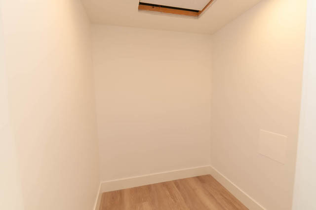 Empty bedroom with hardwood floors and white walls. - Suite - 778 Crystal Court, North Vancouver