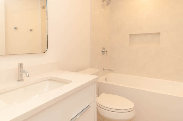 Spacious bathroom with dual sinks, marble countertops, and a modern toilet. - Suite - 778 Crystal Court, North Vancouver