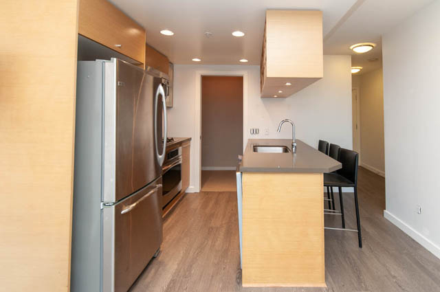 Bright kitchen with stainless steel appliances, light wood cabinets, and hardwood floors. - 1102-833 Seymour Street, Vancouver Downtown