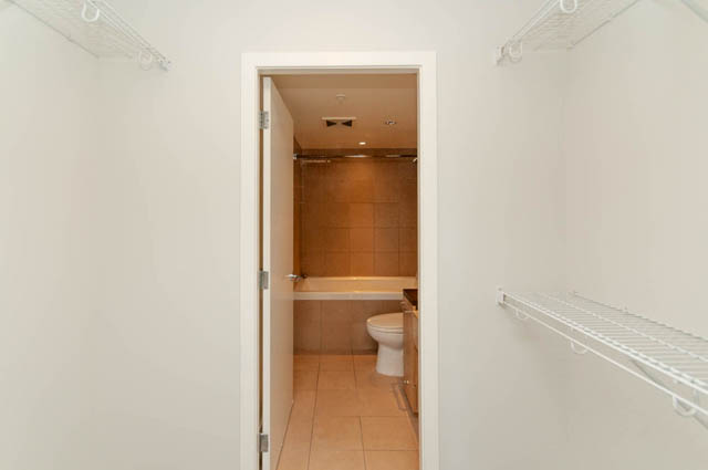 Bright laundry room with white shelves and tiled floor. - 1102-833 Seymour Street, Vancouver Downtown