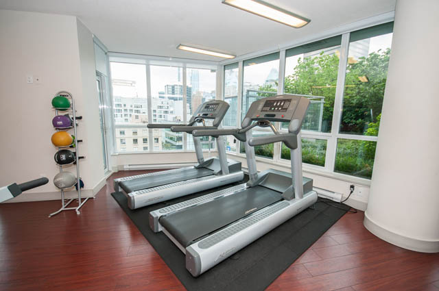 Bright gym with hardwood floors, city view, and cardio equipment. - 1102-833 Seymour Street, Vancouver Downtown