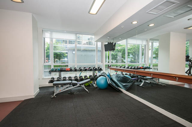 Bright gym with large windows, exercise equipment, and city view. - 1102-833 Seymour Street, Vancouver Downtown