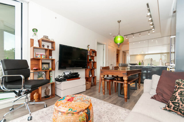 Spacious living room with hardwood floors, modern furniture, and a large TV, perfect for a cozy stay.