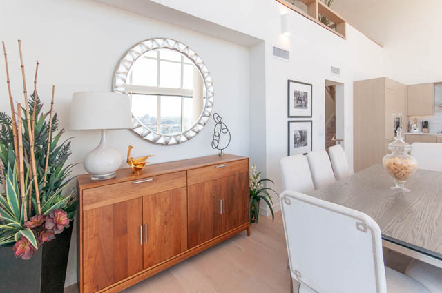 Bright dining area with wooden credenza, round mirror, and city view. - 2818  - 89 Nelson Street, Vancouver Downtown