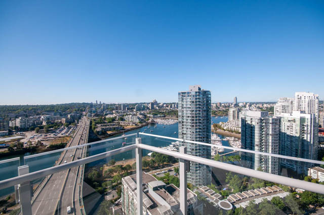 Penthouse with stunning city view, overlooking marina and highway, featuring modern furnishings and balcony.