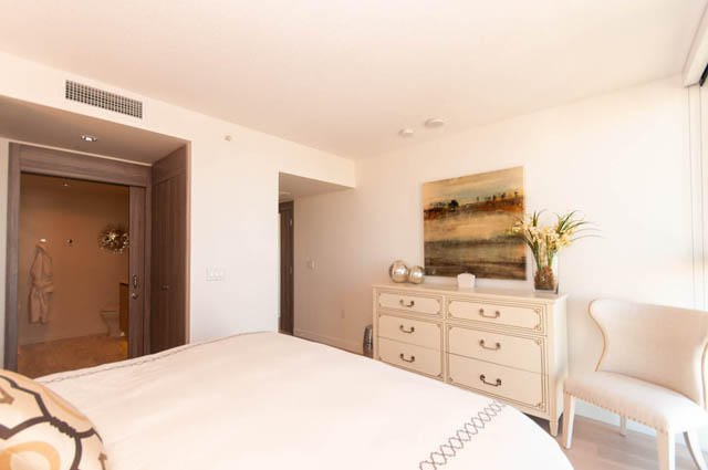 Spacious bedroom with elegant white furniture, artwork, and a cozy ambiance. - 2818  - 89 Nelson Street, Vancouver Downtown