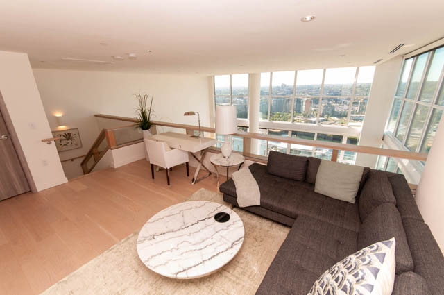 Spacious penthouse living room with hardwood floors, a marble coffee table, and a stunning city view. - 2818  - 89 Nelson Street, Vancouver Downtown