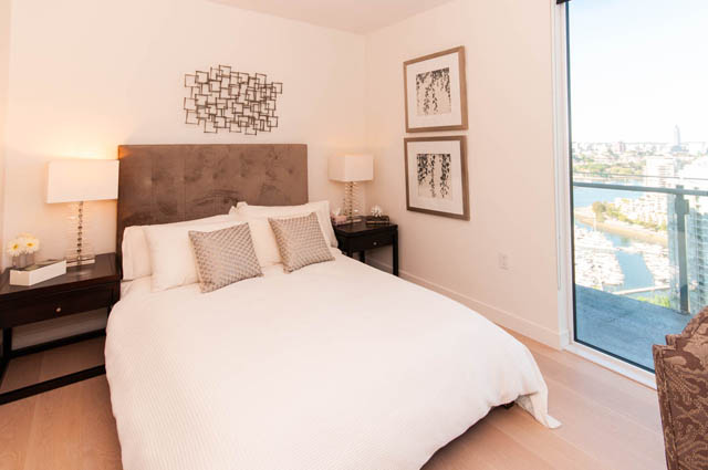 Spacious penthouse bedroom with a city view, featuring a large bed, modern decor, and hardwood floors. - 2818  - 89 Nelson Street, Vancouver Downtown
