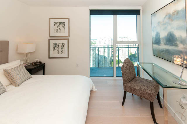 Spacious penthouse bedroom with hardwood floors, a city view, and a desk setup. - 2818  - 89 Nelson Street, Vancouver Downtown