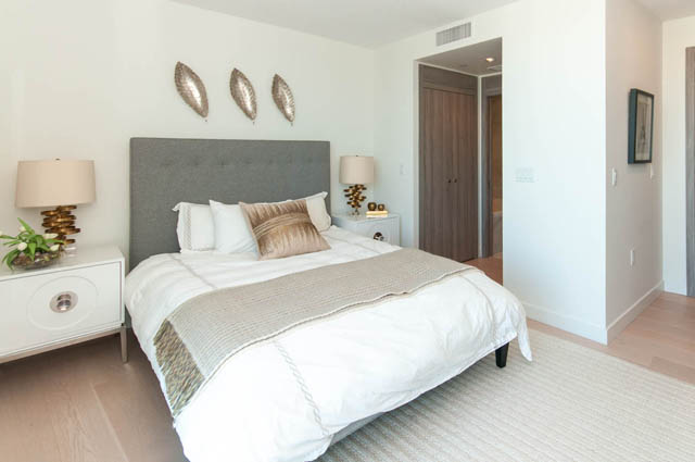 Spacious bedroom with modern decor, featuring a gray upholstered headboard and white bedding. - 2818  - 89 Nelson Street, Vancouver Downtown