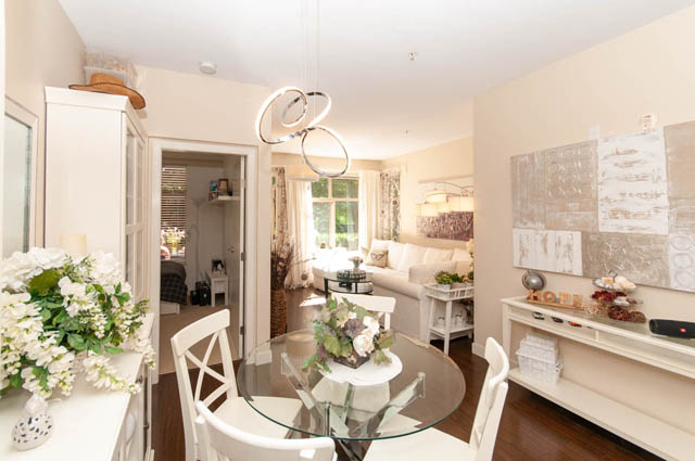 Spacious open-concept living with modern decor, glass dining table, and cozy living room. - 102-1633 Mackay Avenue, North Vancouver