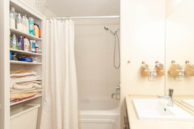 Furnished bathroom with a bathtub, shower, and neatly organized shelves. - 102-1633 Mackay Avenue, North Vancouver
