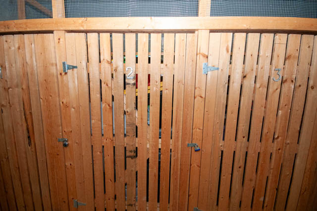 Spacious bathroom with wooden paneling and numbered stalls. - 102-1633 Mackay Avenue, North Vancouver