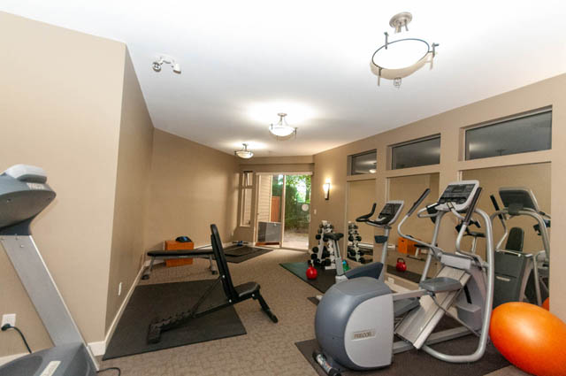 Spacious, well-lit gym with cardio machines and free weights, perfect for fitness enthusiasts. - 102-1633 Mackay Avenue, North Vancouver