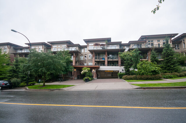 The front of Touchstone from across the street, with balconies over the landscaped entrance - 102-1633 Mackay Avenue, North Vancouver