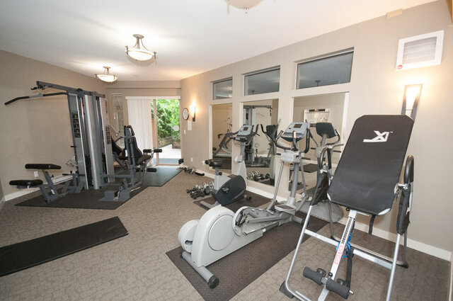 The building gym with a weight machine, elliptical, exercise bike and mirrors - 102-1633 Mackay Avenue, North Vancouver