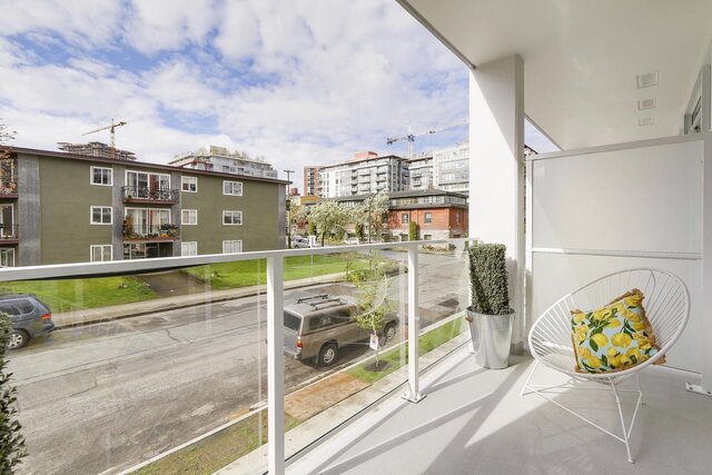 balcony with glass railings, potted plant, outdoor chair, and city view - 212-311 East 6th Avenue, Vancouver East Side