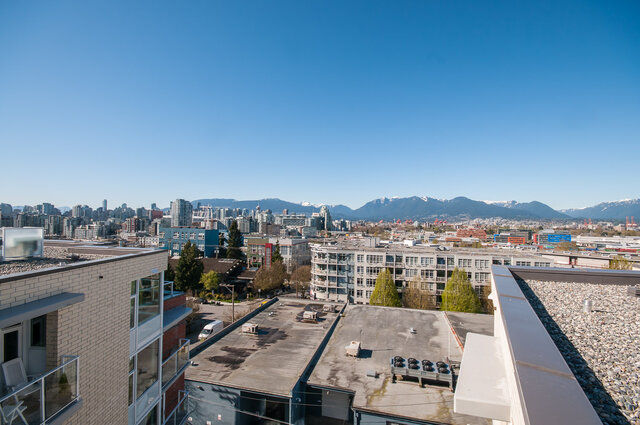 A view showing city buildings, snow-capped mountains in the distance, and a clear blue sky. - 212-311 East 6th Avenue, Vancouver East Side
