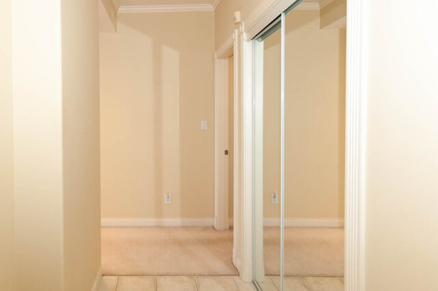 Hallway with carpeted flooring and a sliding glass door. - 607-160 E 13th Street, North Vancouver