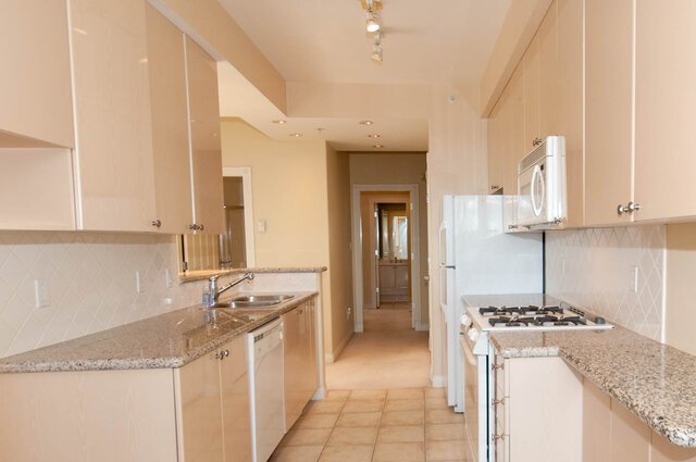 Bright kitchen with granite countertops and white appliances. - 607-160 E 13th Street, North Vancouver