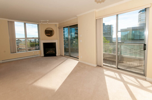 Bright living room with floor-to-ceiling city views and gas fireplace. - 607-160 E 13th Street, North Vancouver