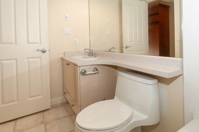 Bathroom with large mirror and light wood vanity. - 607-160 E 13th Street, North Vancouver