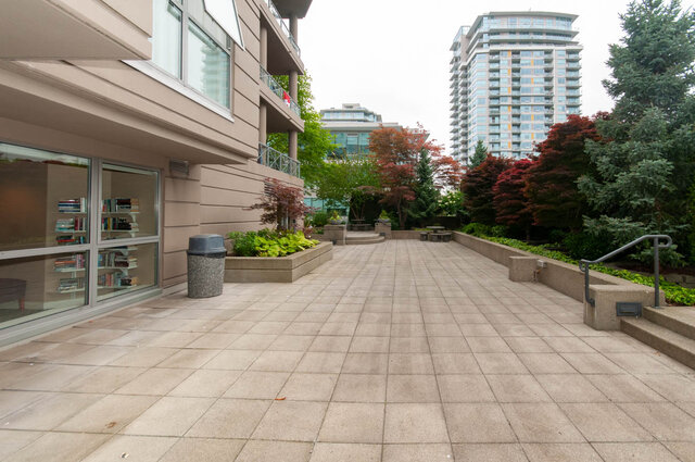 Courtyard with stone tile patio and lush greenery. - 607-160 E 13th Street, North Vancouver