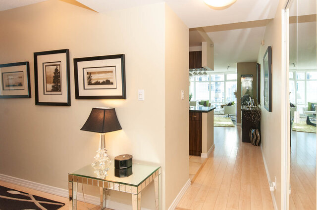 Spacious living room with hardwood floors, modern decor, and a city view. - 905 - 1199 Marinaside Cres., Vancouver Downtown