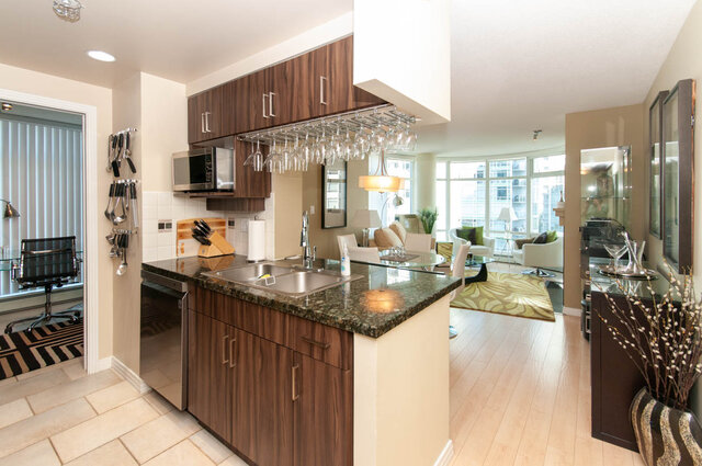 Modern kitchen with granite countertops, hardwood floors, and a city view. - 905 - 1199 Marinaside Cres., Vancouver Downtown