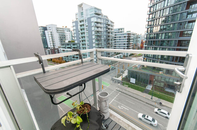 Furnished balcony with city view, modern apartment, and cozy seating area. - 1006 -1618 Quebec Street, Vancouver East Side