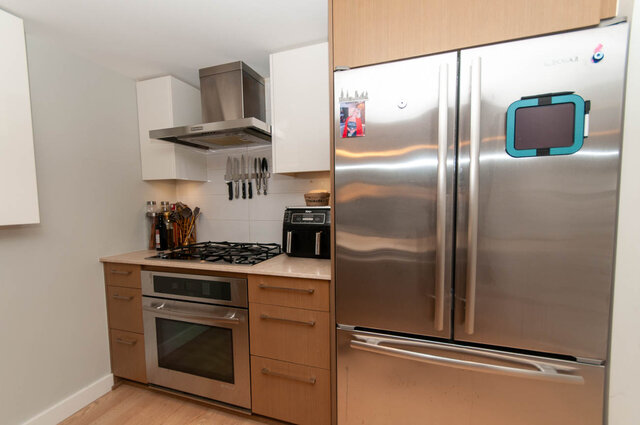 Bright kitchen with stainless steel appliances, wooden cabinets, and a gas stove, perfect for a cozy living space.
