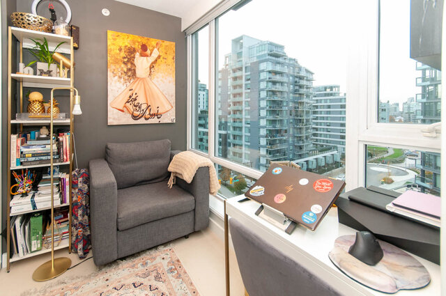 Spacious living room with a cozy corner sofa, bookshelf, and stunning city view. - 1006 -1618 Quebec Street, Vancouver East Side