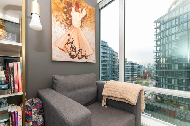 Spacious living room with a cozy corner sofa, city view, and vibrant wall art. - 1006 -1618 Quebec Street, Vancouver East Side