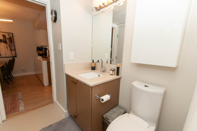 Compact bathroom with light wood cabinets and a modern sink setup. - 1006 -1618 Quebec Street, Vancouver East Side
