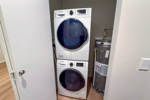 This is a laundry room containing a stacked Samsung washer and dryer unit and a water heater. - G 3- 2030 East 20th Ave, Vancouver East Side