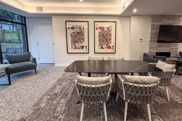 dining area with a large table, chairs, framed artwork on the wall, floor-to-ceiling windows, and a television