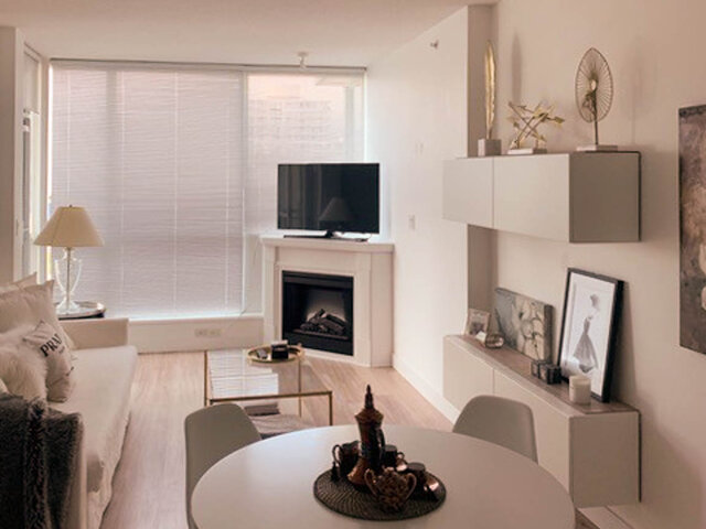 Spacious living room with modern fireplace, sleek TV, and minimalist decor. - 806 - 138 East Esplanade, North Vancouver